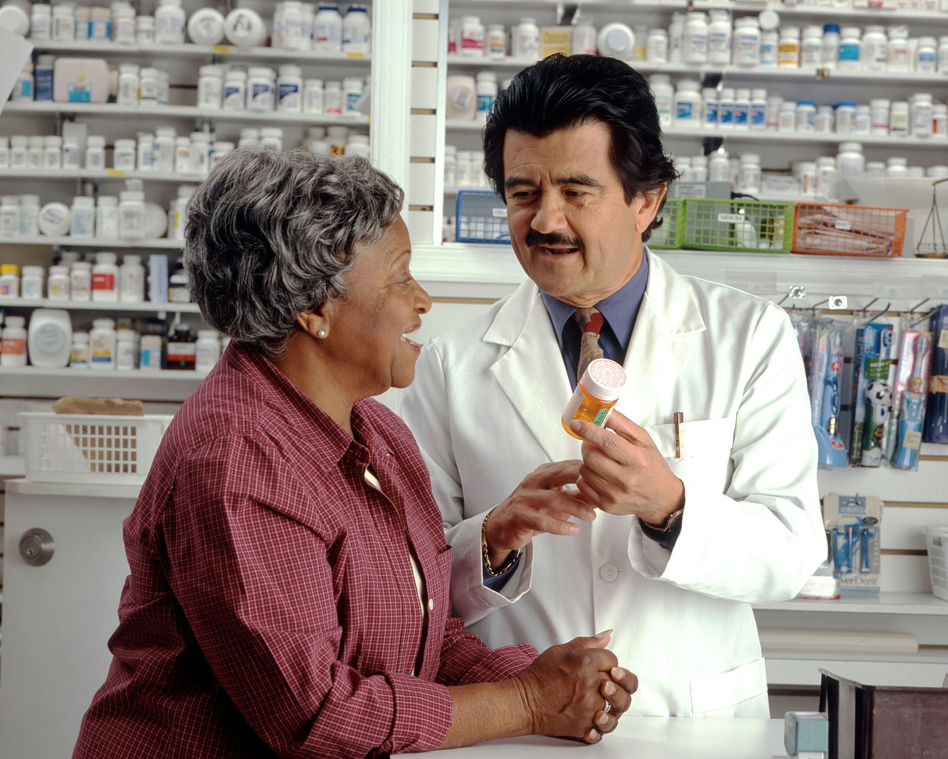 Pharmacist is giving patient their medication in a bottle